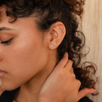 A woman with curly hair wearing the Diamond Flatback Studs Set.