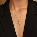 The Opal Moon & Star Necklace features a crescent moon and star pendant, shown styled with a black V-neck blazer.