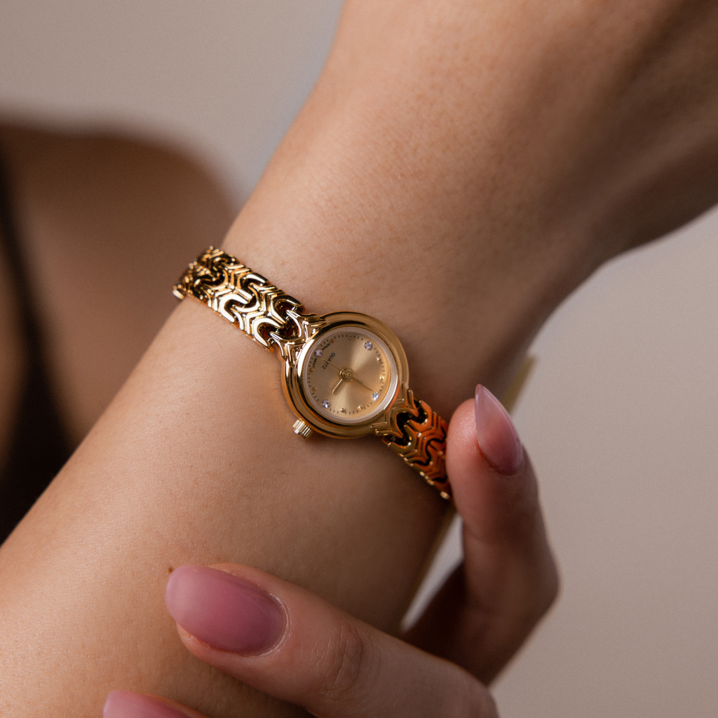 Close up of our Wavy Link Timepiece watch on a wrist with a neutral background