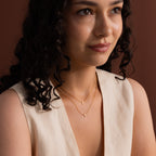 Model wearing two dainty gold cross charm necklaces in 16 and 18 inches.