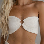A woman pairs the Sprinkle Diamond Body Chain with a white bandeau top, showcasing wavy blonde hair and bare shoulders for an effortlessly chic, layered look.