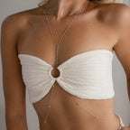 A woman styles the Sprinkle Diamond Body Chain with a white bandeau top featuring a circular ring detail for a chic, layered look.