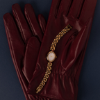 Our Cherry Blossom Timepiece watch on a maroon leather glove against a blue background