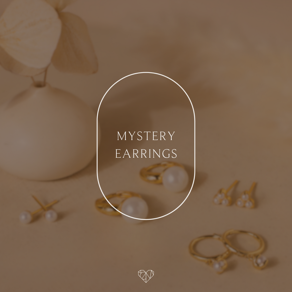 Mystery Earrings from our collection are showcased beside a cream vase, with "Mystery Earrings" featured at the center.