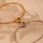 Two Rolo Circle Charm Bracelets in 18K Gold, each featuring a detachable hinged circle clasp for easy wear or adding charms, displayed on a beige background.