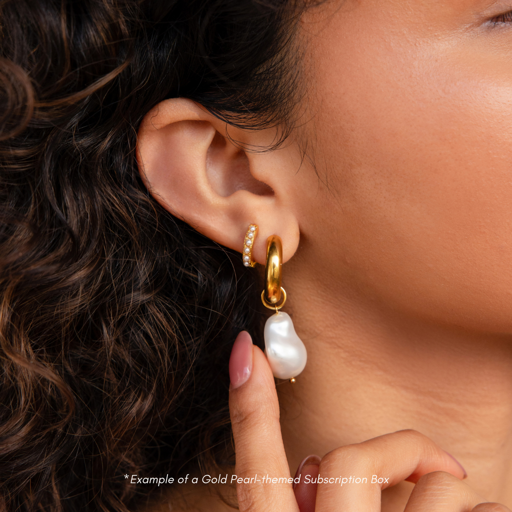 Close-up of a woman's ear wearing a gold hoop and pearl earring—an elegant look you could receive in your next Monthly Earrings Subscription Box.