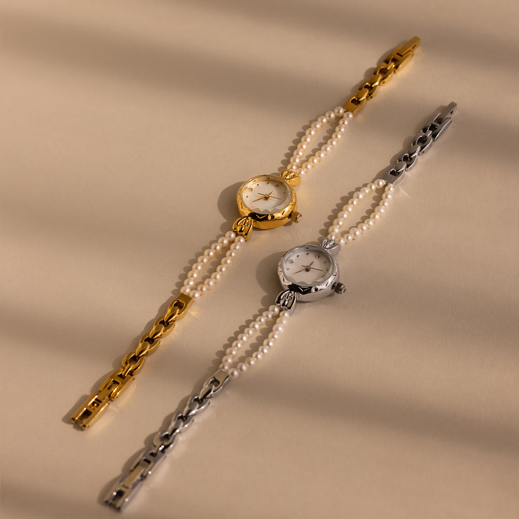 Two Beaded Pearl Timepiece watches, one in gold and one in silver, are showcased on a beige background. Each watch exudes the timeless charm of vintage elegance.