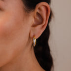 Close-up of a woman's ear wearing Twisted Mixed Metal Hoops, showcasing their elegant two-tone gold and silver design for a modern, stylish look.