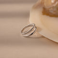 Chelsea Duo Ring in silver with rope and smooth band design styled against a shell accent.