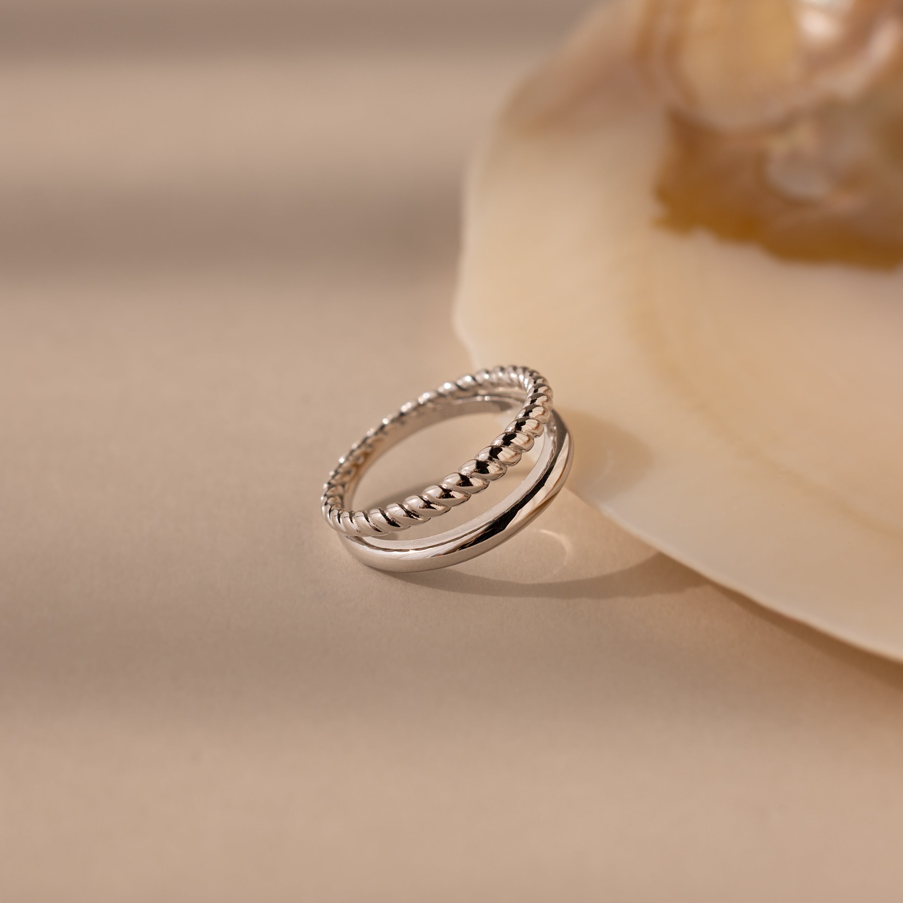 Chelsea Duo Ring in silver with rope and smooth band design styled against a shell accent.