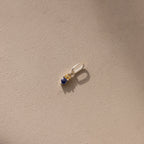 Silver Dainty Duo Birthstone Charm with topaz and sapphire. The design features two birthstones stacked vertically in prong setting with a large jump ring attached to the top. 