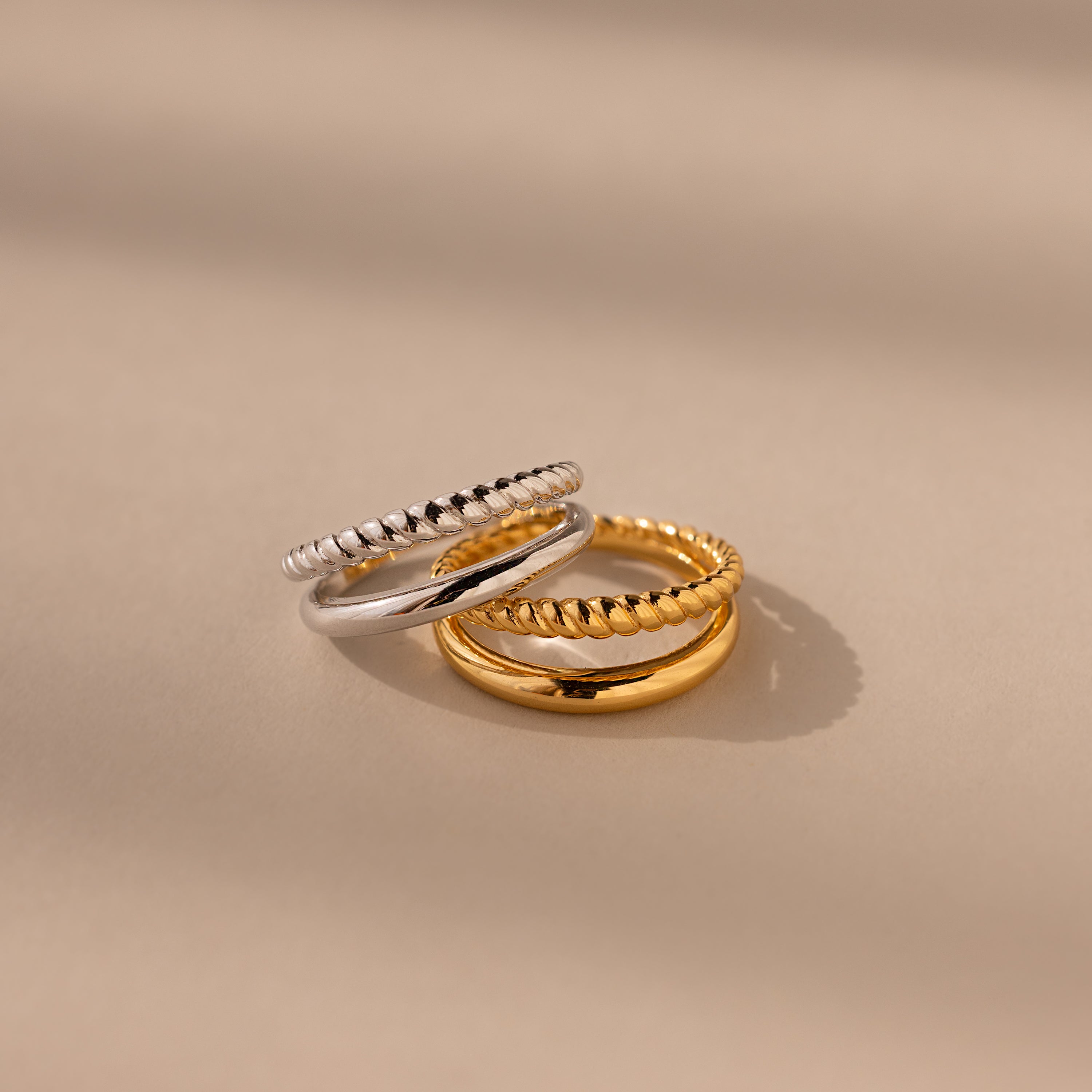 Chelsea Duo Ring in gold and silver versions stacked together on neutral background.