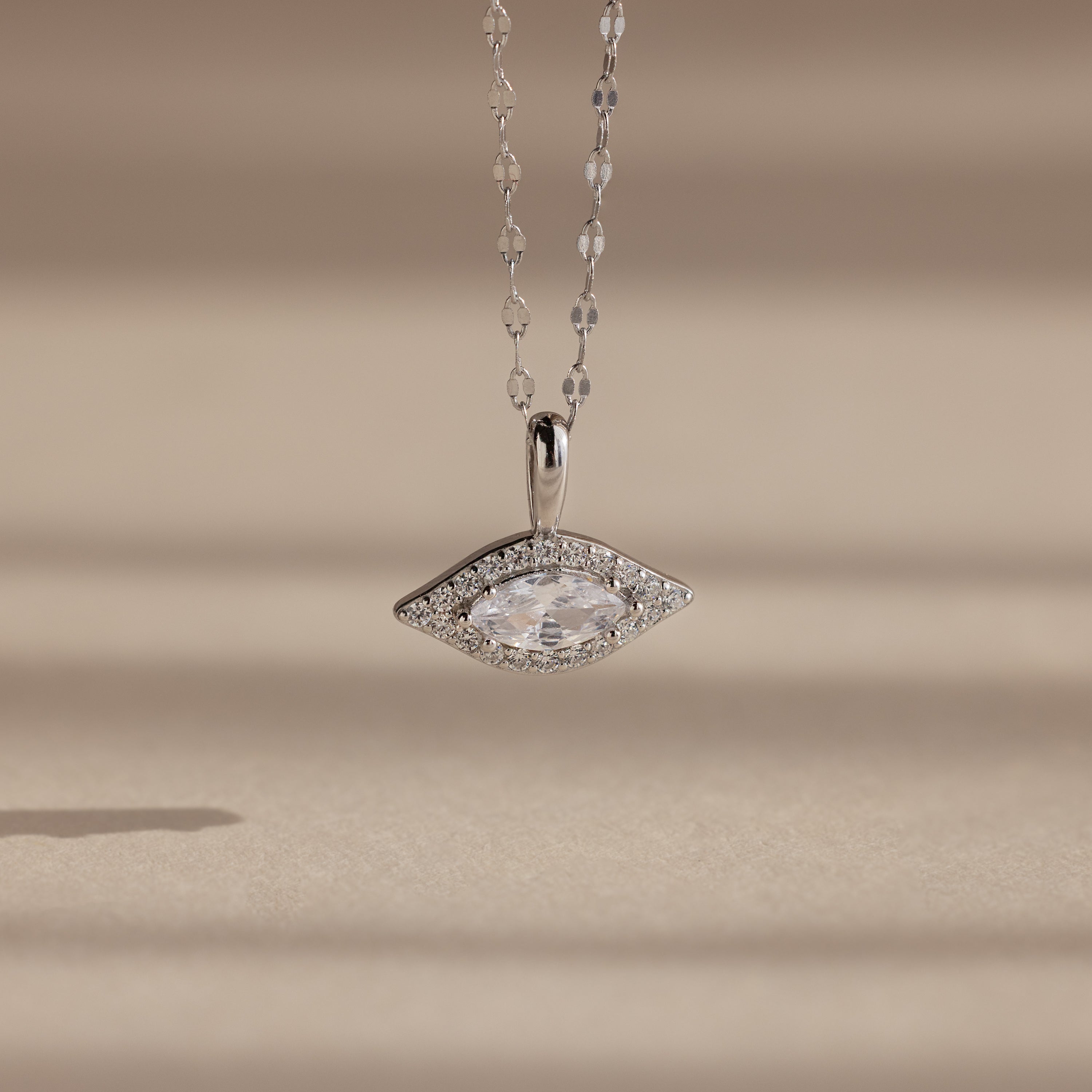 Silver Pave Evil Eye Charm hanging from a silver mirror chain