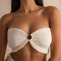 A woman wearing a silver Sprinkle Diamond Body Chain layered over a textured ivory bandeau top. The delicate chain drapes from the neck and connects at the center with a vertical line of tiny bezel-set diamonds, then cascades down around the torso in a flattering silhouette.