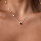 Close-up of a woman’s neck wearing the Multiple Teardrop Birthstone Necklace, featuring delicate silver teardrops and a small green birthstone pendant—an elegant, meaningful gift for someone special.