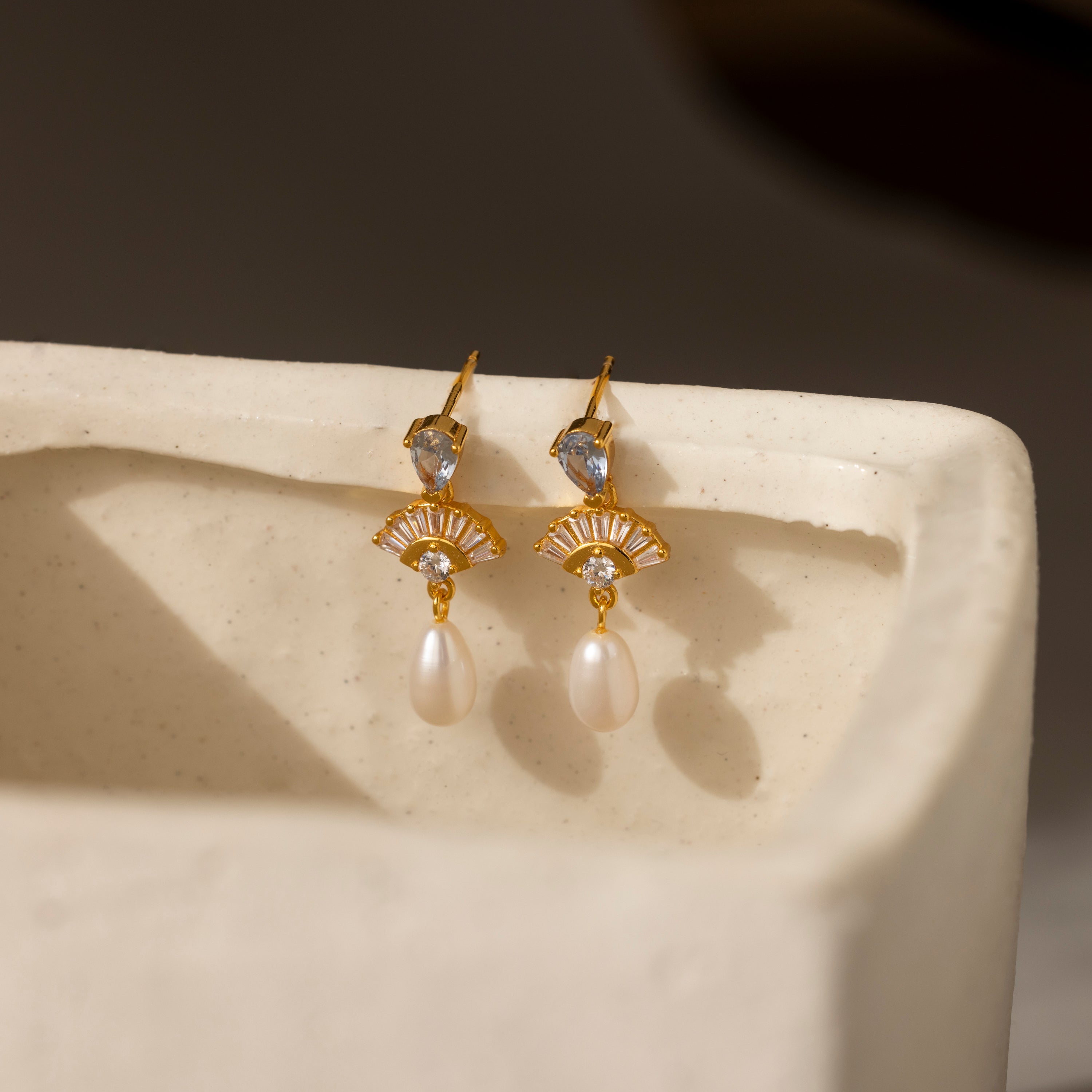 Aquamarine Pearl Drop Earrings in 18K Gold feature crystal accents for vintage elegance—ideal wedding earrings, shown on a white ceramic surface.