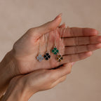Gemstone Clover Necklace trio with onyx, malachite, and tiger’s eye gemstones on delicate chains held in hands against a.