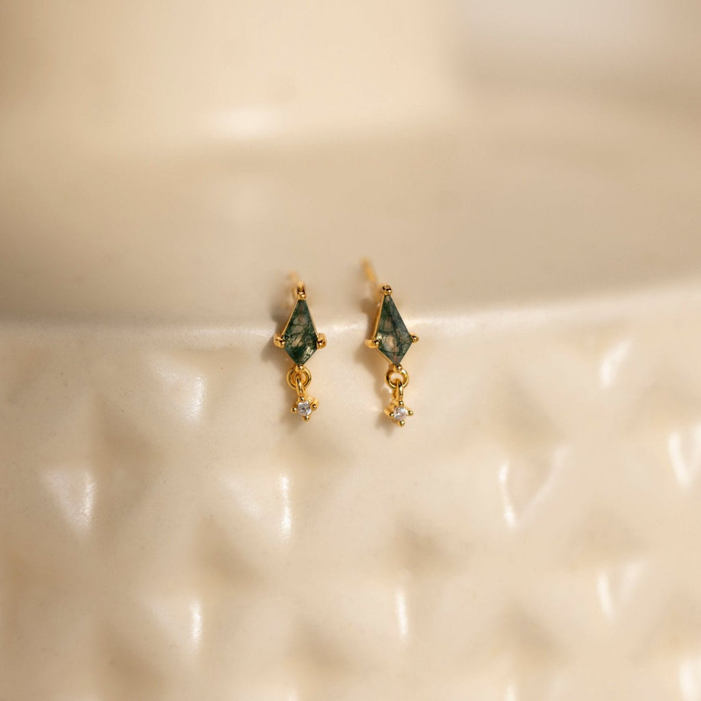 Agate Kite Drop Earrings with green moss agate accents and dangling crystals, shown on a textured cream surface.