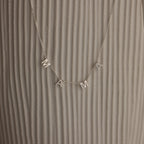 The Alice Letter Name Necklace in Sterling Silver with MAMA charms is displayed on a textured beige background—a perfect personalized necklace and thoughtful Christmas gift.