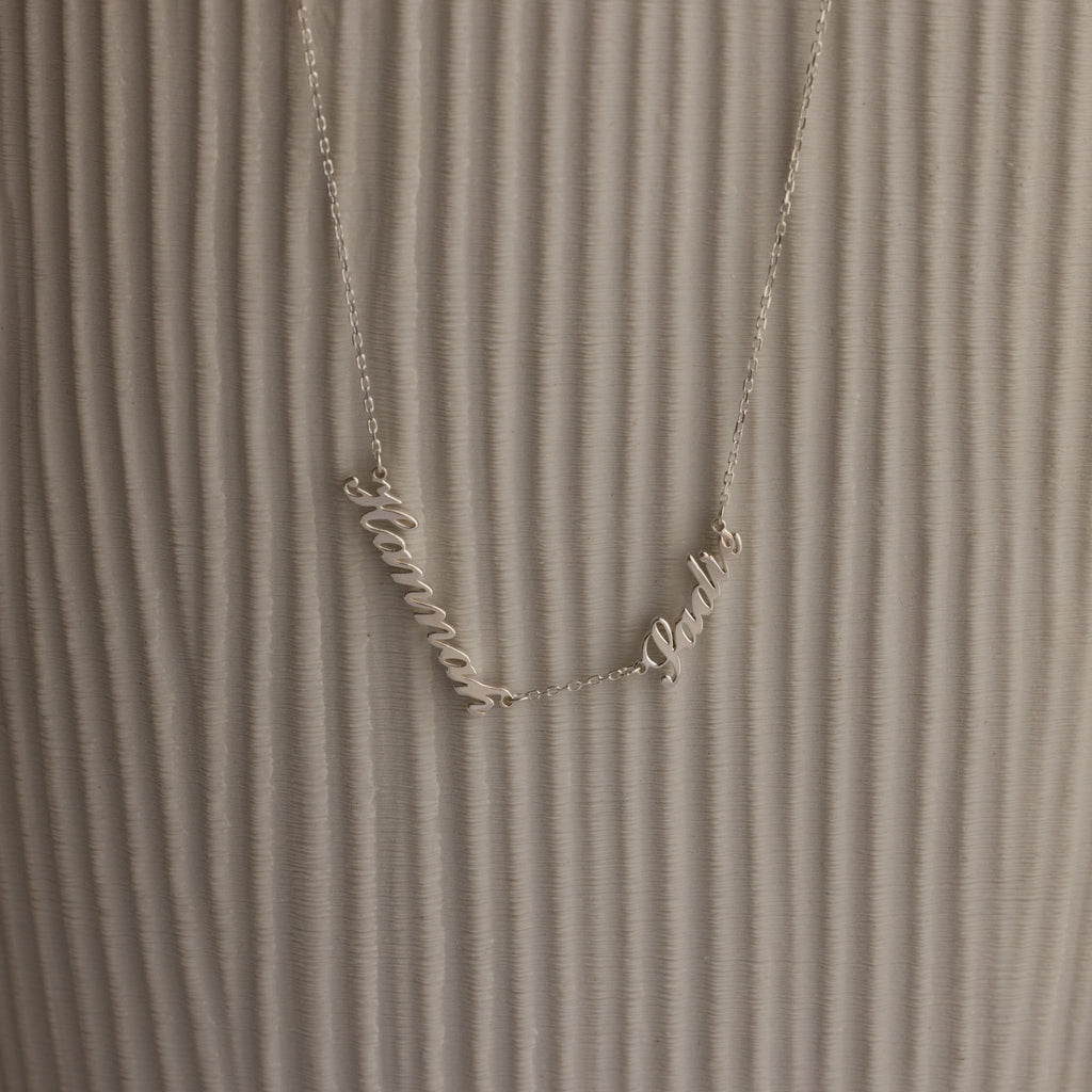 Carrie Multiple Name Necklace with Hanna and Pablo on a textured, light background—a perfect personalized jewelry piece.