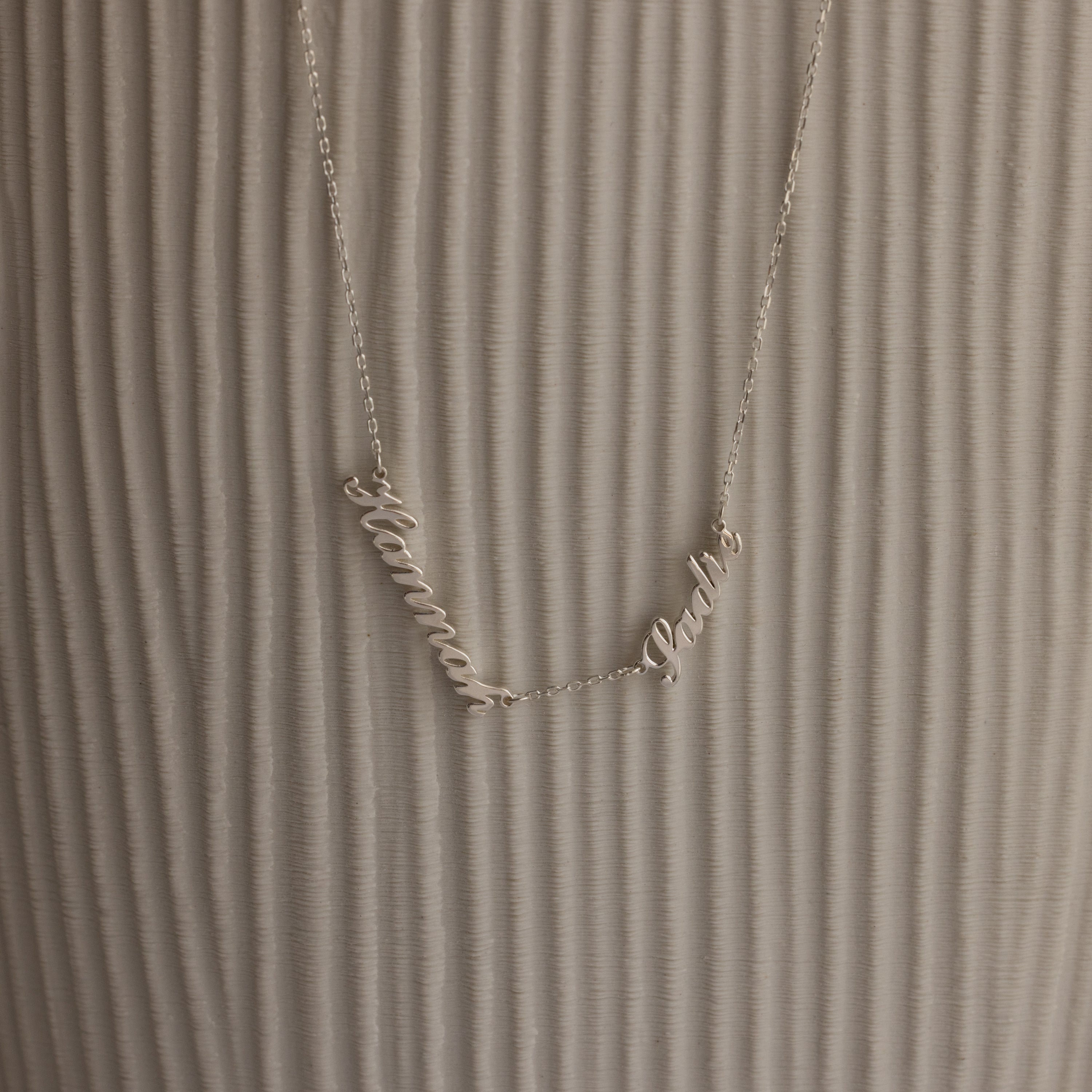 Carrie Multiple Name Necklace with Hanna and Pablo on a textured, light background—a perfect personalized jewelry piece.
