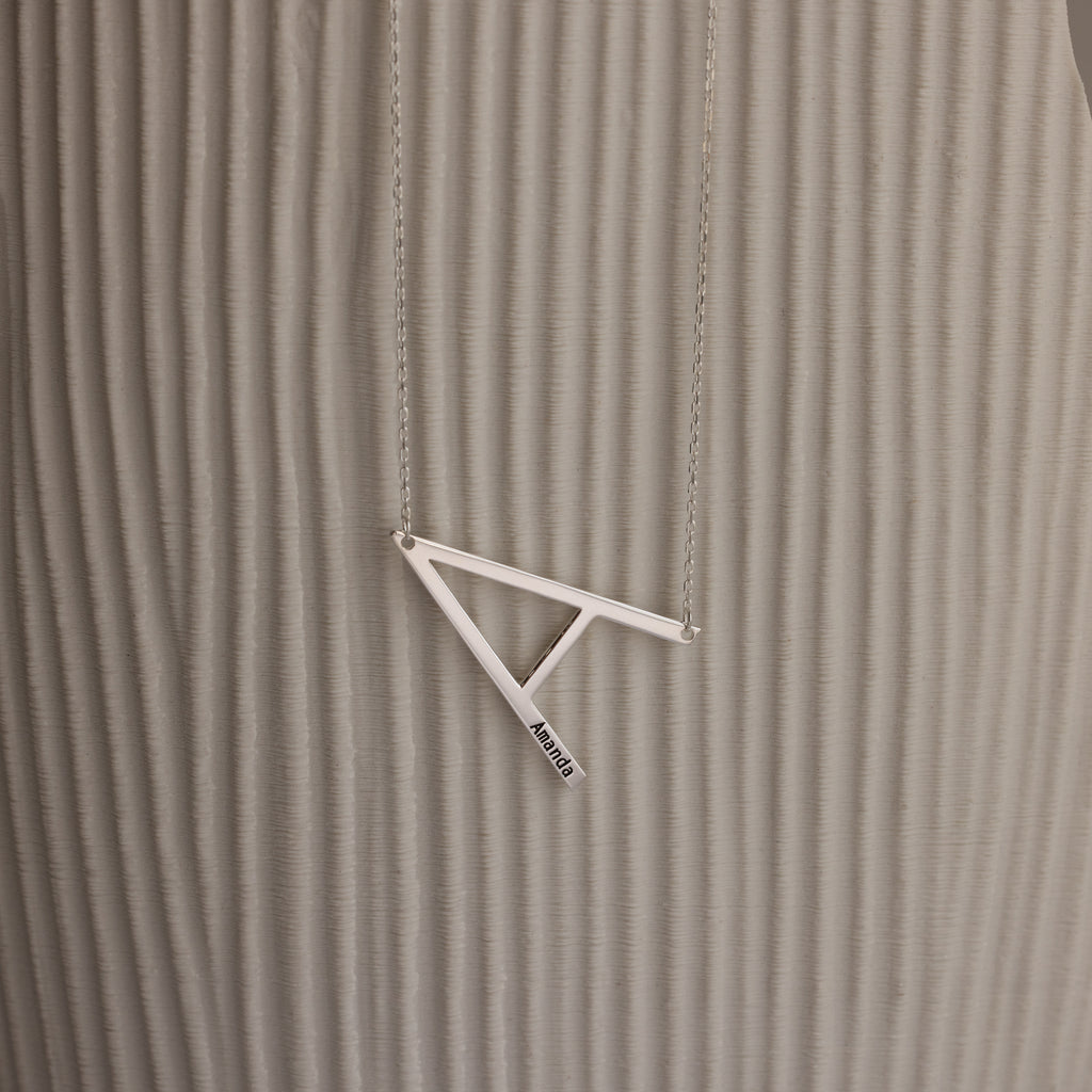 Large Sideways Initial Necklace in Sterling Silver showcased on a textured beige background.