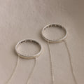 The Inner Circle Necklace features two silver rings with chains: one engraved "I love you always," the other with "A + H 05.16.24" inside, creating a modern amulet style.