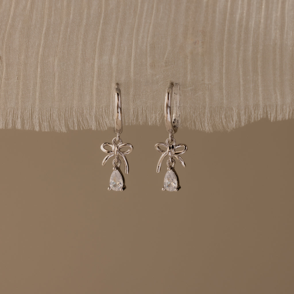 Flatlay of our Teardrop Ribbon Charm Hoops in Silver