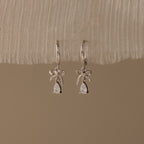 Flatlay of our Teardrop Ribbon Charm Hoops in Silver