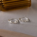 Two Grace Script Name Rings in Sterling Silver engraved with Amelia and Aurora in elegant script, displayed on a light surface—an ideal personalized ring for any occasion.
