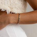 The Lace Diamond Bangle adds a touch of luxury to any outfit, pairing elegantly with a white textured top and white pants for a refined, stylish look.