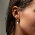 Close-up of a womans ear wearing Aquamarine Pearl Drop Earrings, featuring sparkling gemstones and a dangling pearl for vintage glamour—perfect elegant wedding earrings.