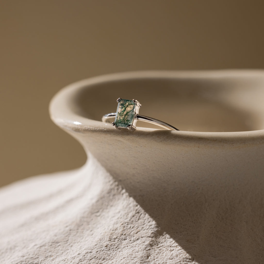 Agate Emerald Ring in silver resting on a vase