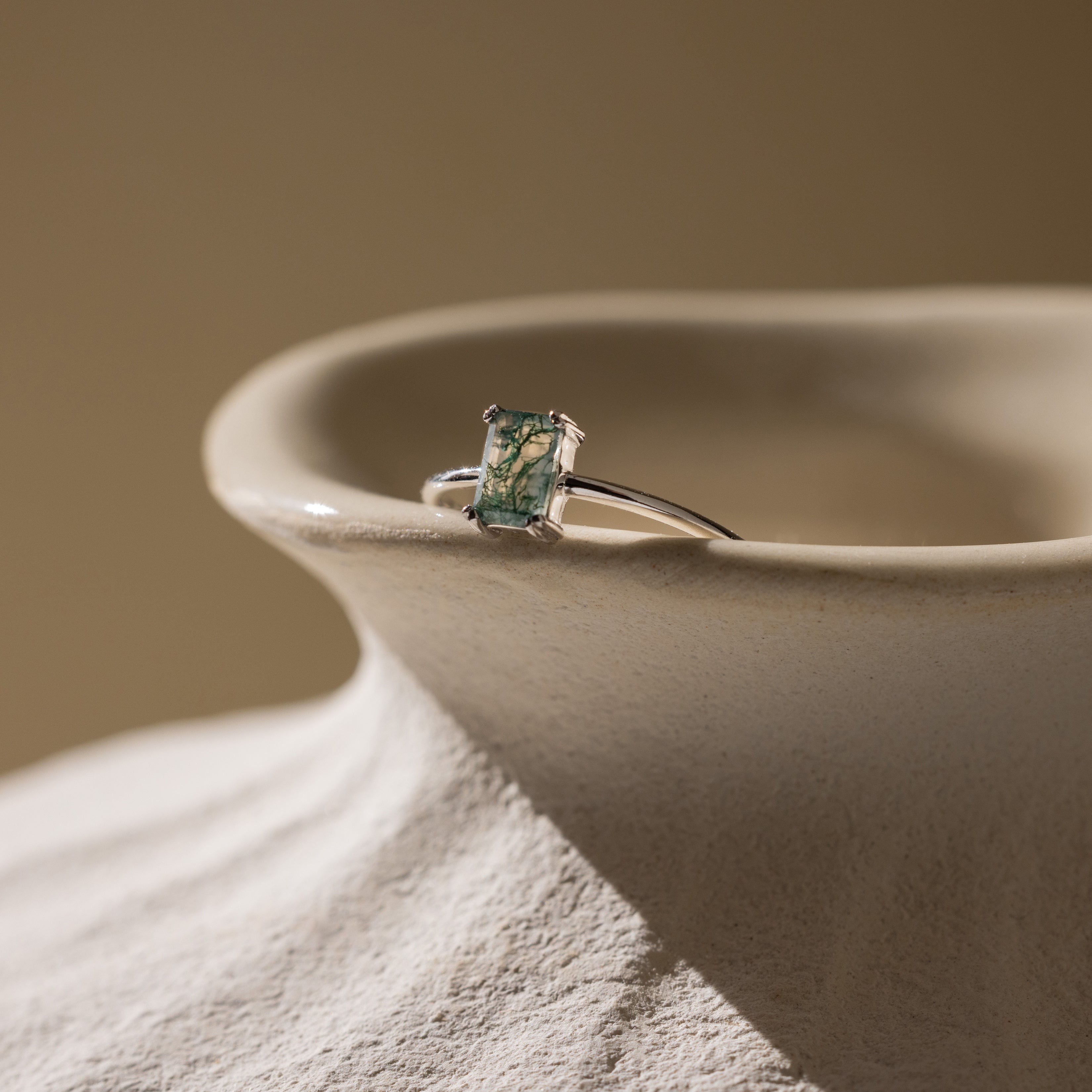 Agate Emerald Ring in silver resting on a vase