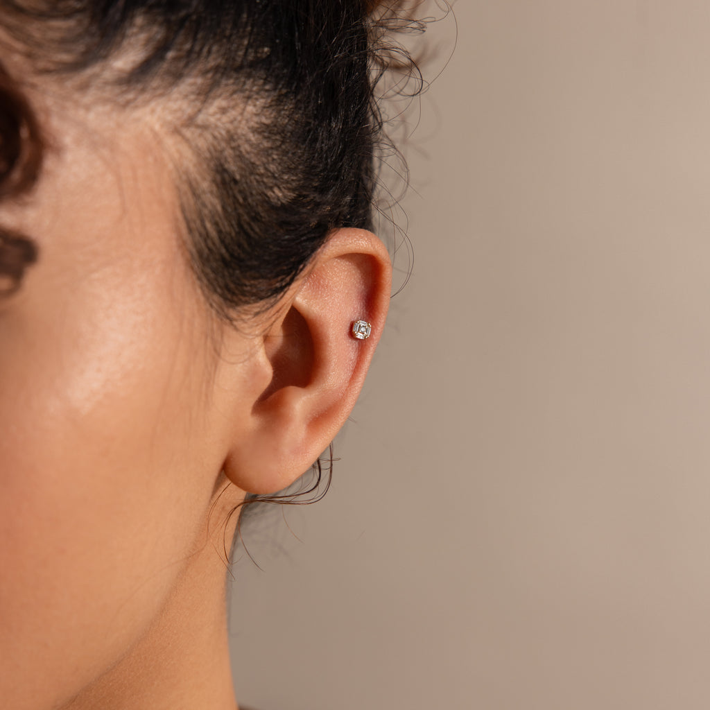 Side view of a gold flatback earring with an Art Deco–style diamond design in the conch.