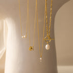 The Dainty Duo Pearl Necklace features gold and pearls, elegantly displayed on a light background—perfect as wedding jewelry or a classic pearl necklace for any occasion.