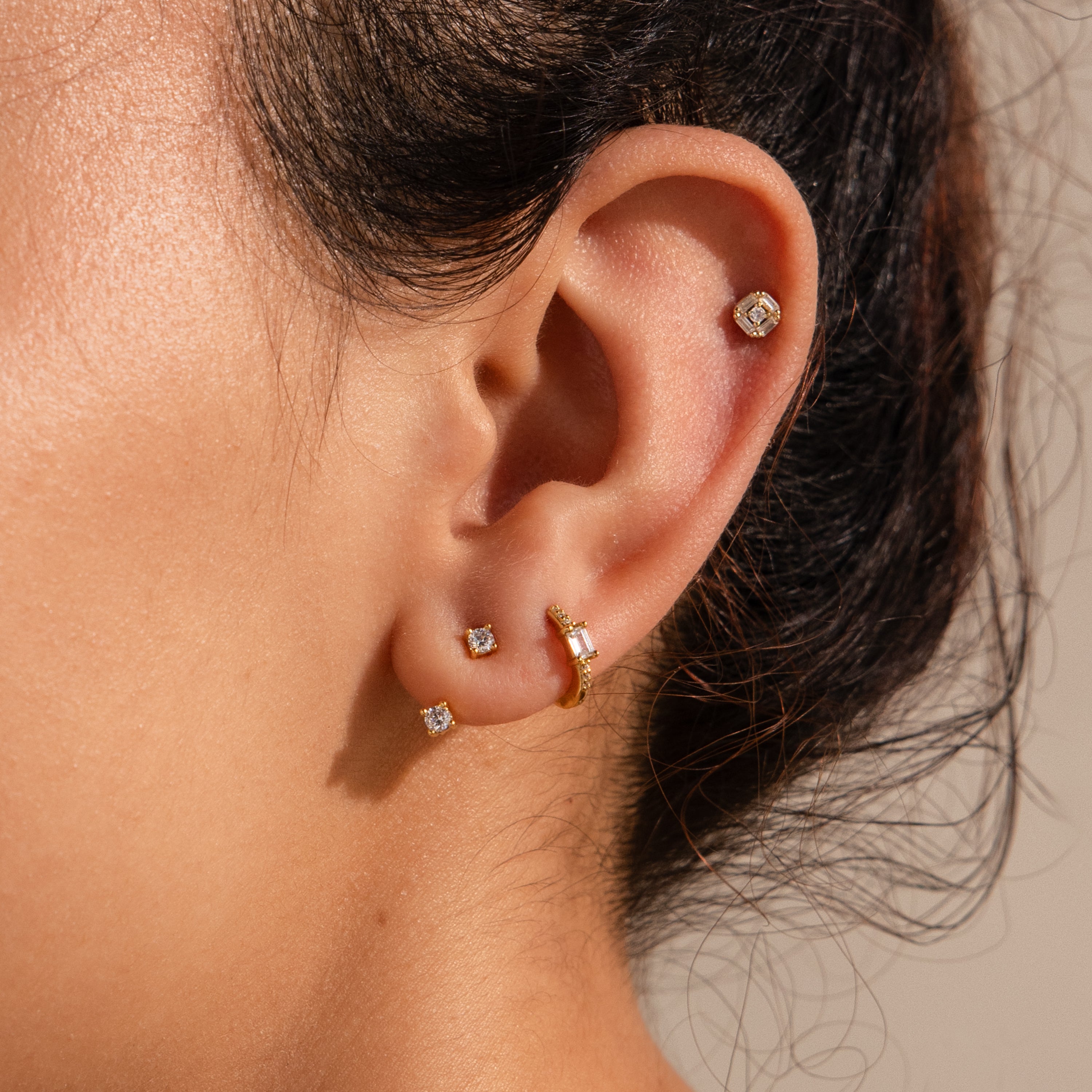 Gold and silver mixed ear stack with three flatback studs and one ear cuff, all in Art Deco style.