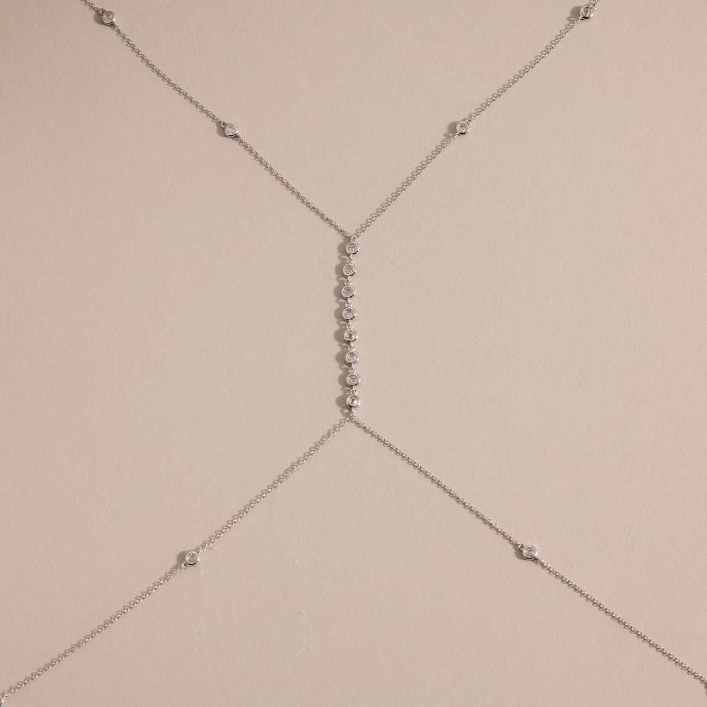 Detailed shot of the silver version of the body chain against a neutral background, featuring the fine chainwork and diamond details.