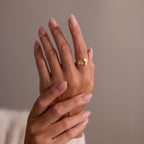 Two hands with manicured nails, one wearing the Hand & Footprint Duo Name Ring in Rose Gold on the index finger—a stunning piece of personalized keepsake jewelry.