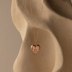 Flatlay of our Handwriting Heart Locket Necklace in Rose Gold with the words "I love you" engraved