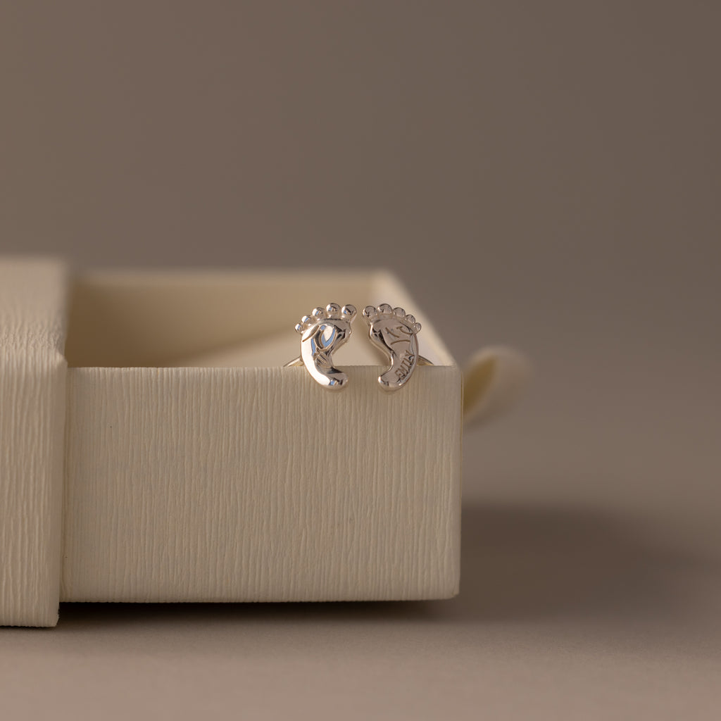 The Hand & Footprint Duo Name Ring in Sterling Silver—an adorable keepsake gift perfect for new parents—features personalized prints, beautifully displayed on a classic band.
