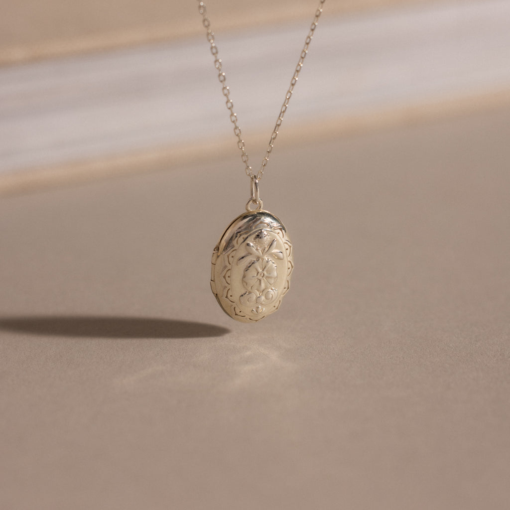 The Floral Handwriting Locket Necklace in Sterling Silver features delicate engraving on a fine chain—a timeless keepsake for treasured memories.