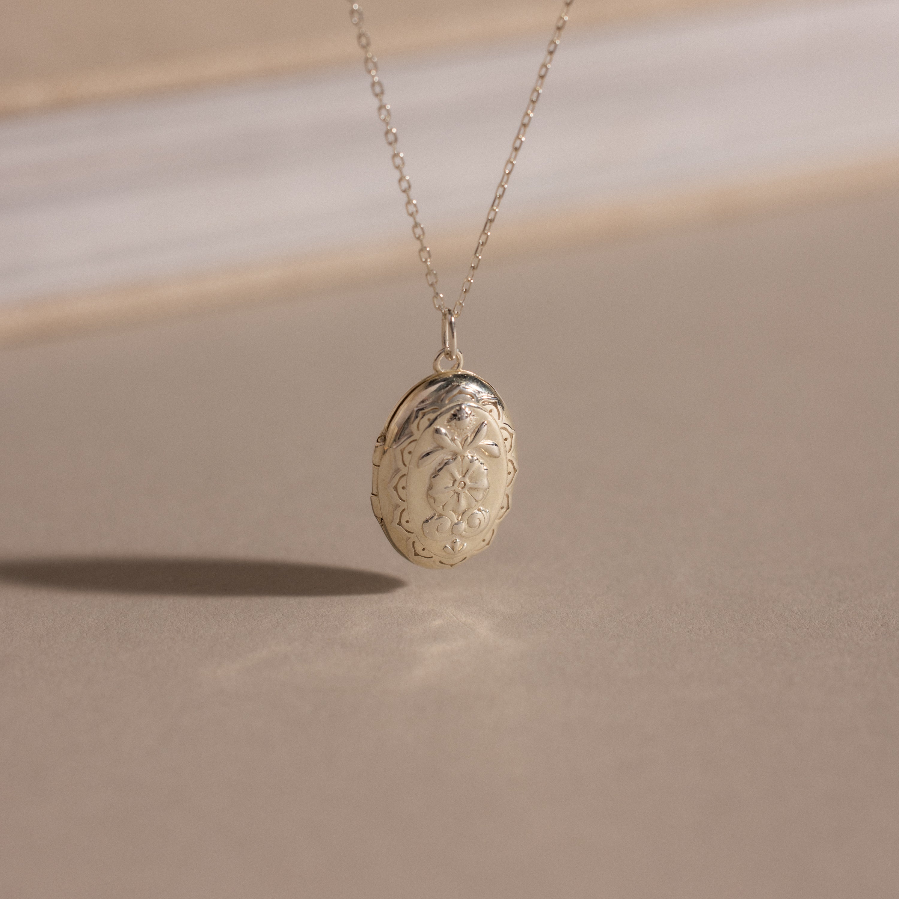 The Floral Handwriting Locket Necklace in Sterling Silver features delicate engraving on a fine chain—a timeless keepsake for treasured memories.