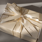 The Gift Box Add-On features a cream-colored box with elegant wrapping, a matching ribbon edged in gold, and printed words for an extra-special finishing touch.
