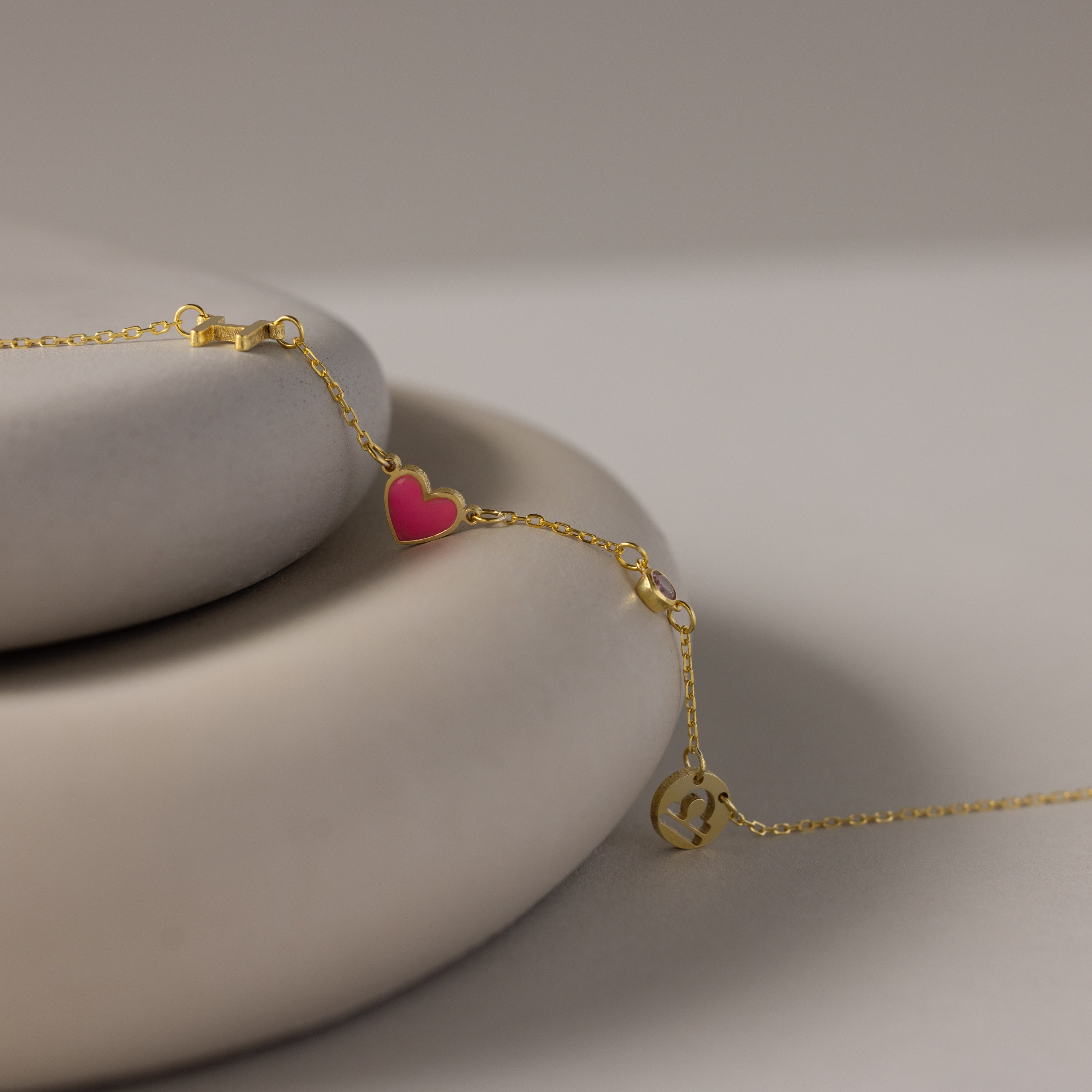 The Dainty Space Charm Necklace in 18K Gold features a delicate design, perfect for pairing with your favorite gold chain bracelet, and looks stunning displayed on a smooth, light surface.