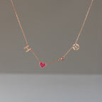 Dainty Space Charm Necklace in Rose Gold featuring gold letters H and J, a pink heart, and a small gem—perfect as a personalized gift for any occasion.