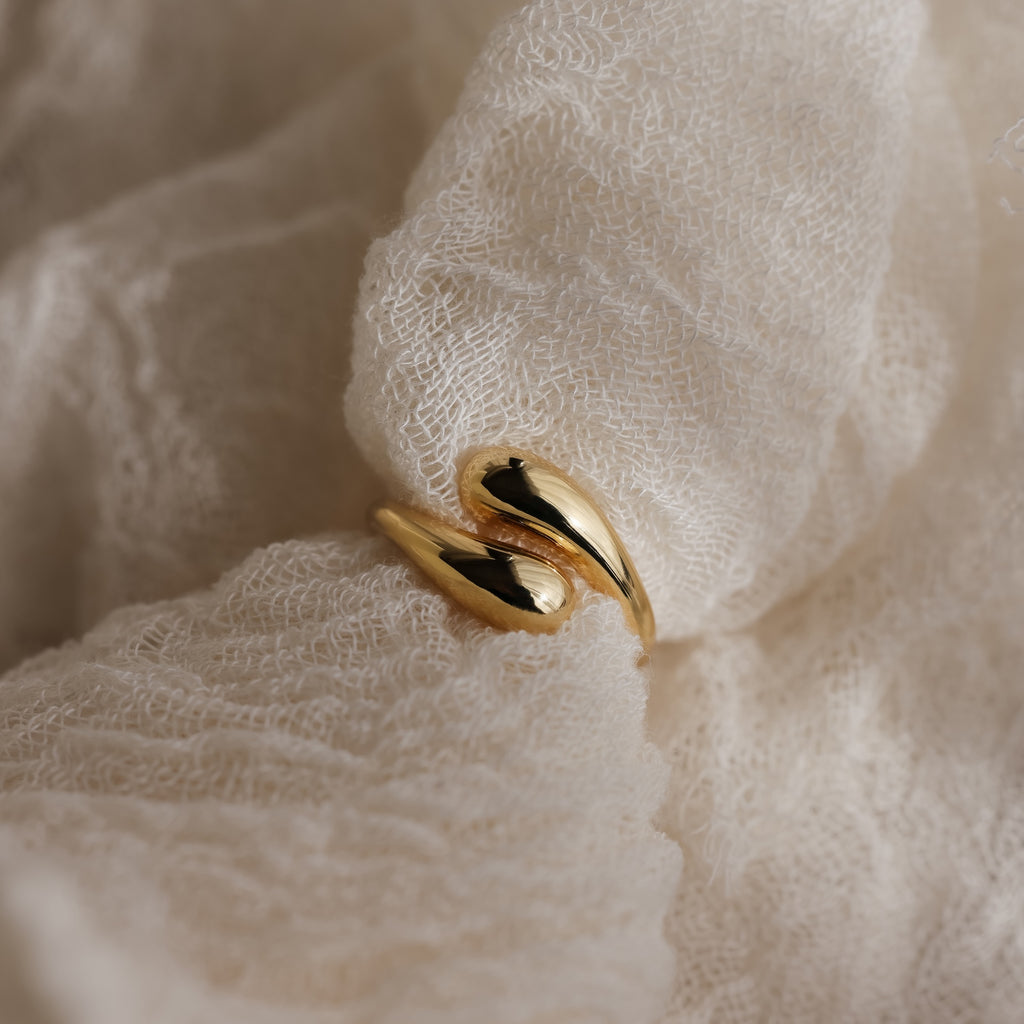 A Duo Dome Ring with a modern design and adjustable band rests on soft, textured white fabric.
