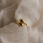 A Duo Dome Ring with a modern design and adjustable band rests on soft, textured white fabric.