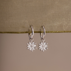 Flatlay of our Diamond Poinsettia Hoops against a green ribbon