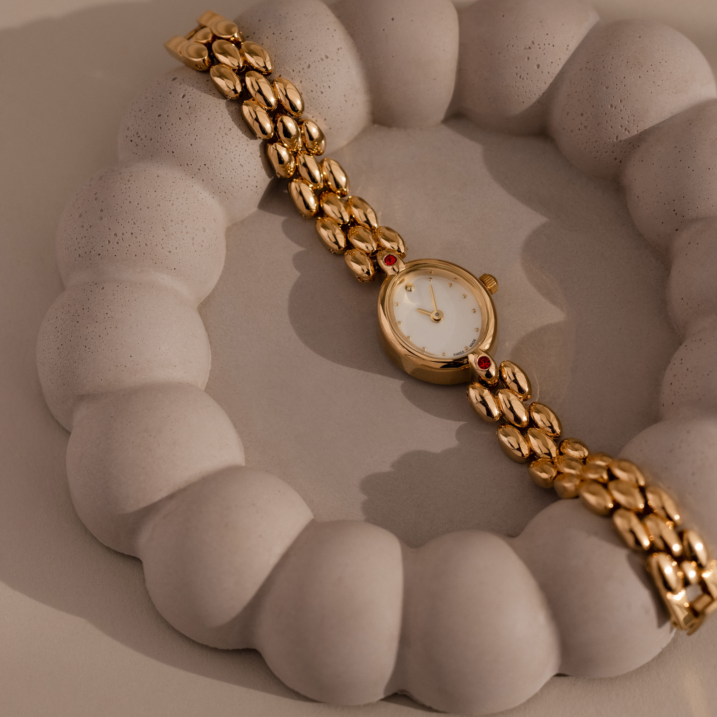 Our Cherry Blossom Timepiece watchon a textured beige surface